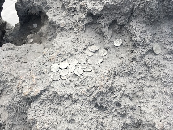 火山灰で灰が積もった硬貨